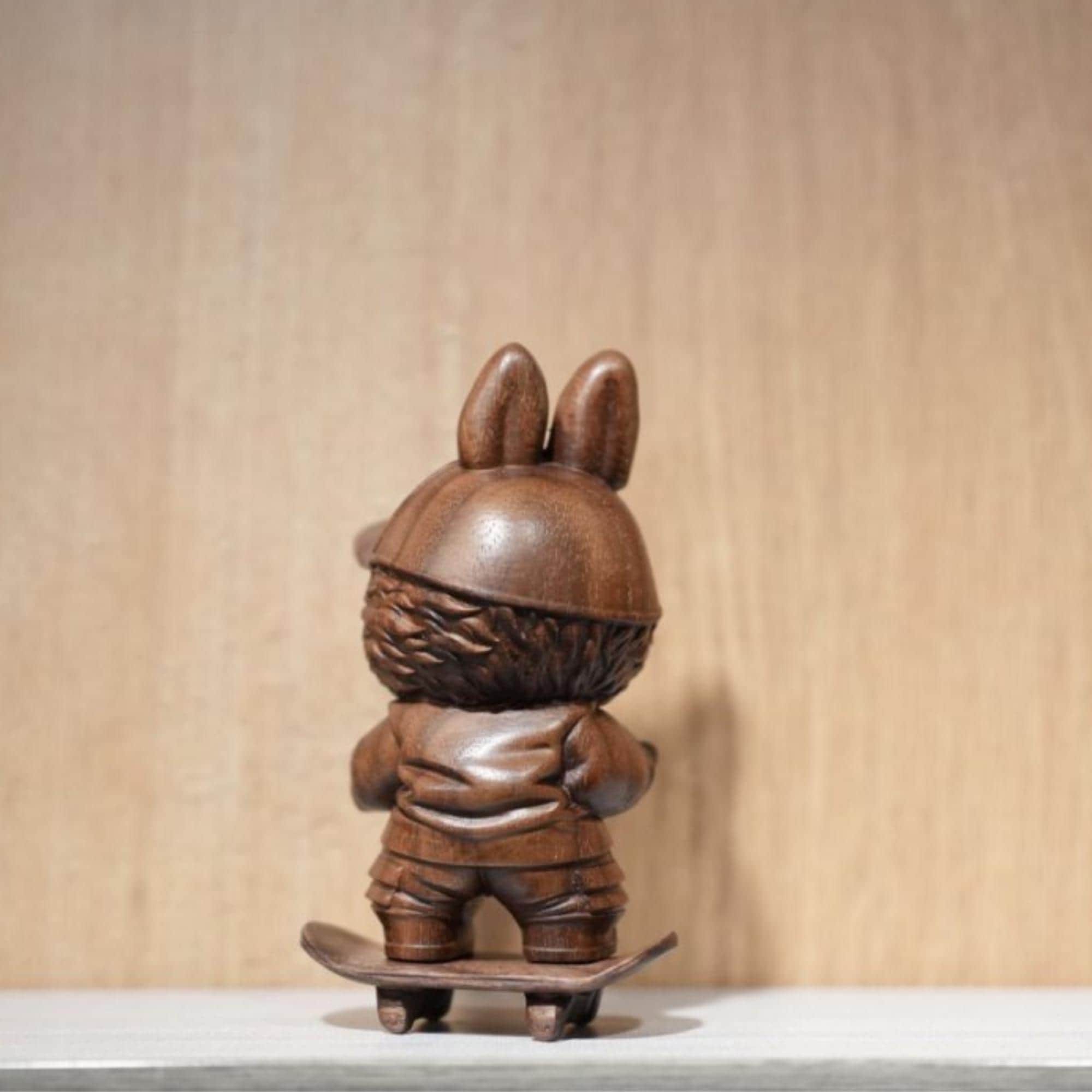Wooden figurine of a character with rabbit ears on a skateboard 