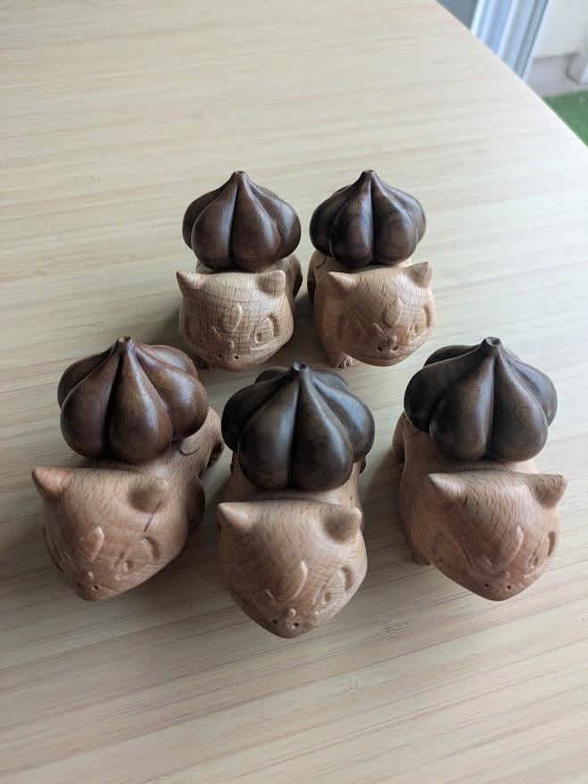 Set of cat-shaped wooden ornaments on a light wooden surface