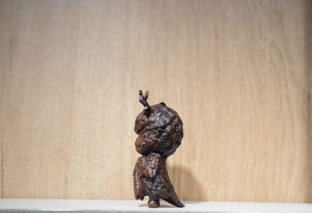 Bronze sculpture of a figure on a plain background