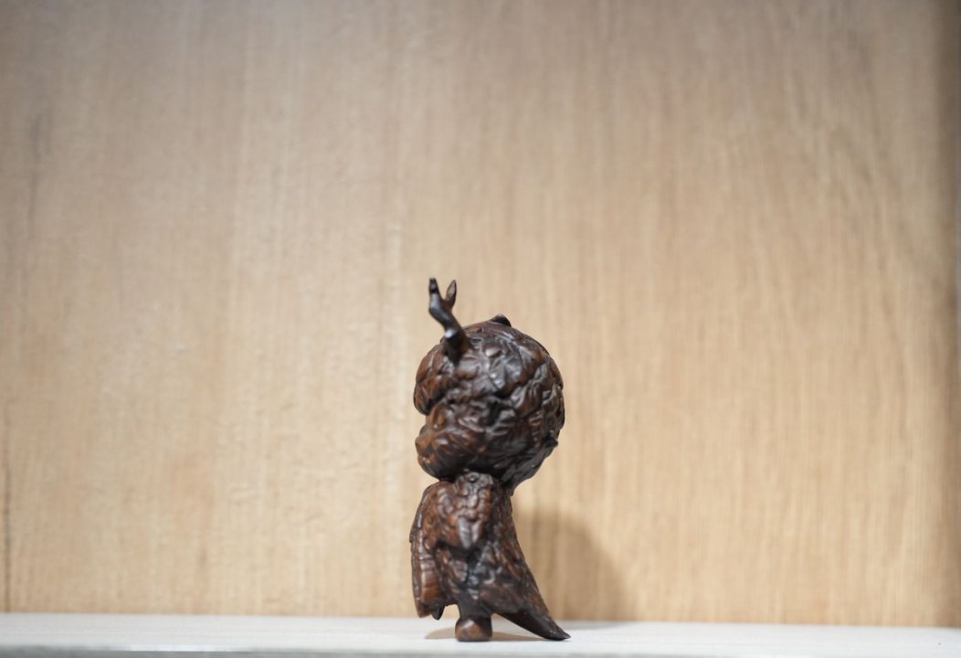 Bronze sculpture of a figure on a plain background