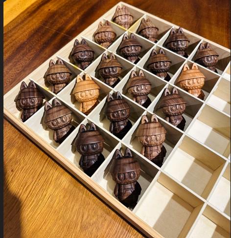 Wooden bubu pieces in a storage box on a wooden surface