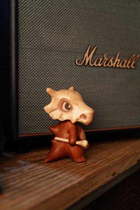 Small figurine of a creature playing drums 
