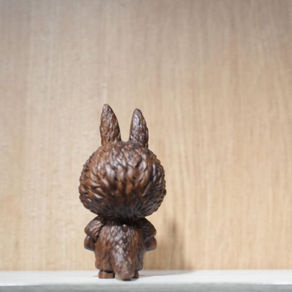 Wooden rabbit figurine on a light wooden background