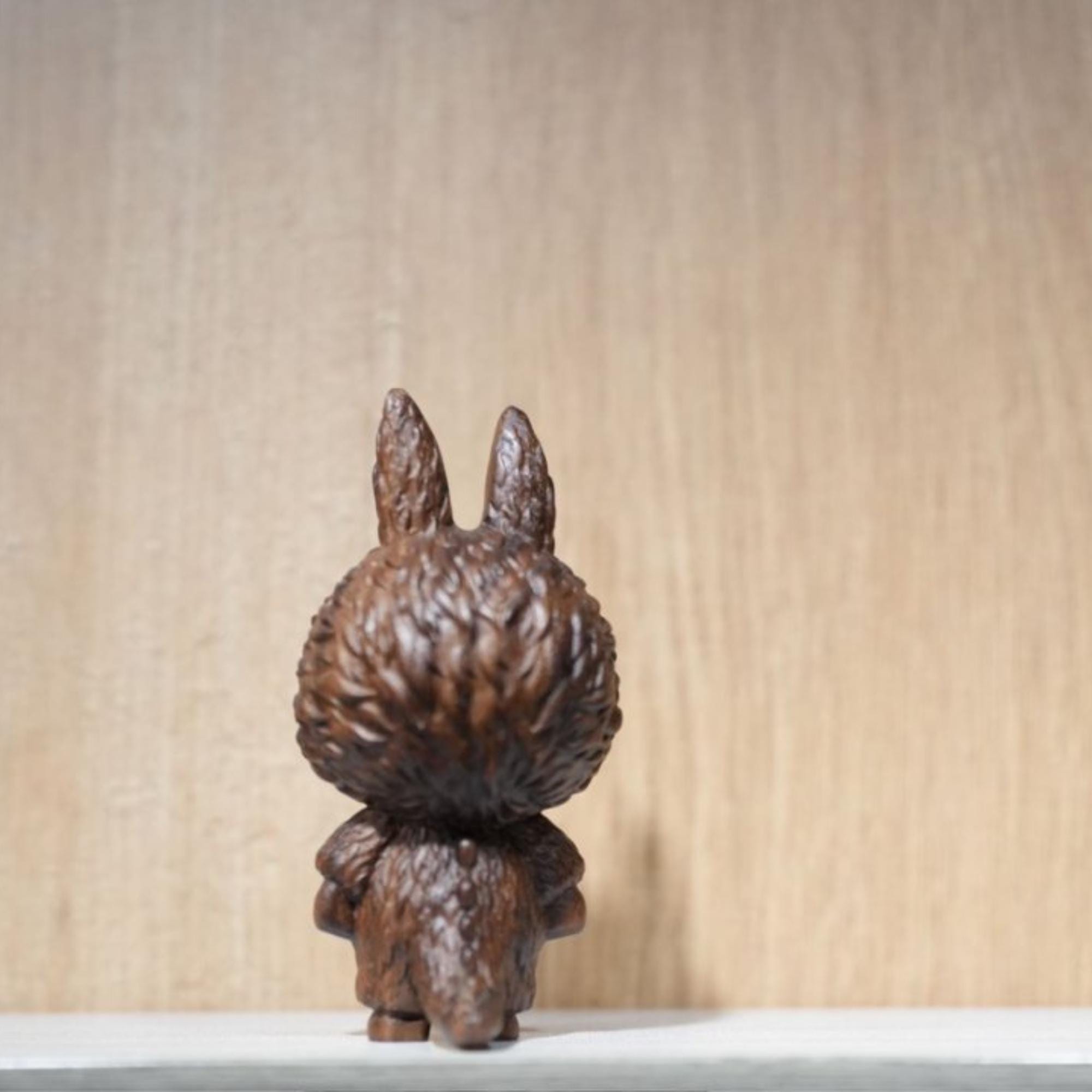 Wooden rabbit figurine on a light wooden background