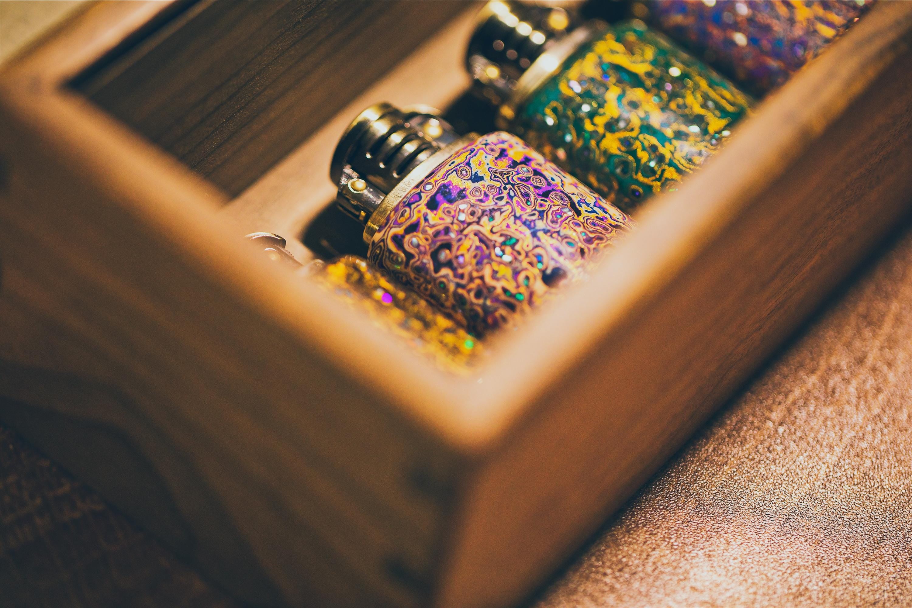 Decorative bottles with colorful patterns inside a wooden box