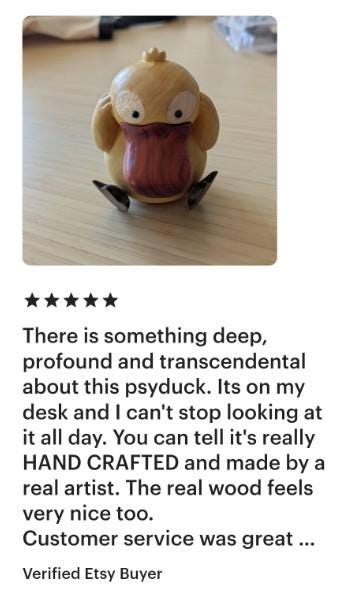 Handcrafted wooden Psyduck figurine on a desk with a five-star rating and positive review.