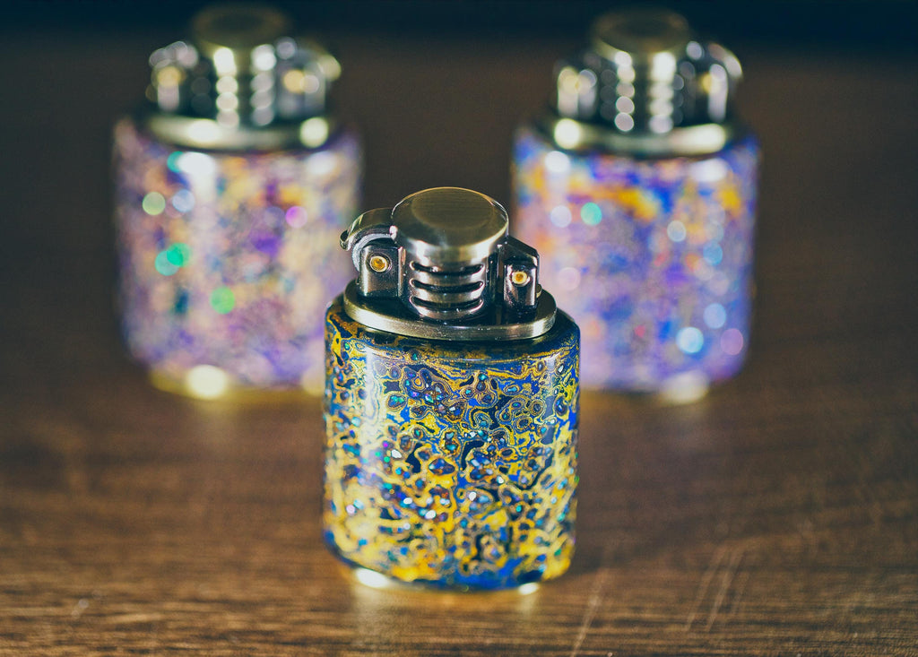 Three decorative lighters with a blue and yellow design
