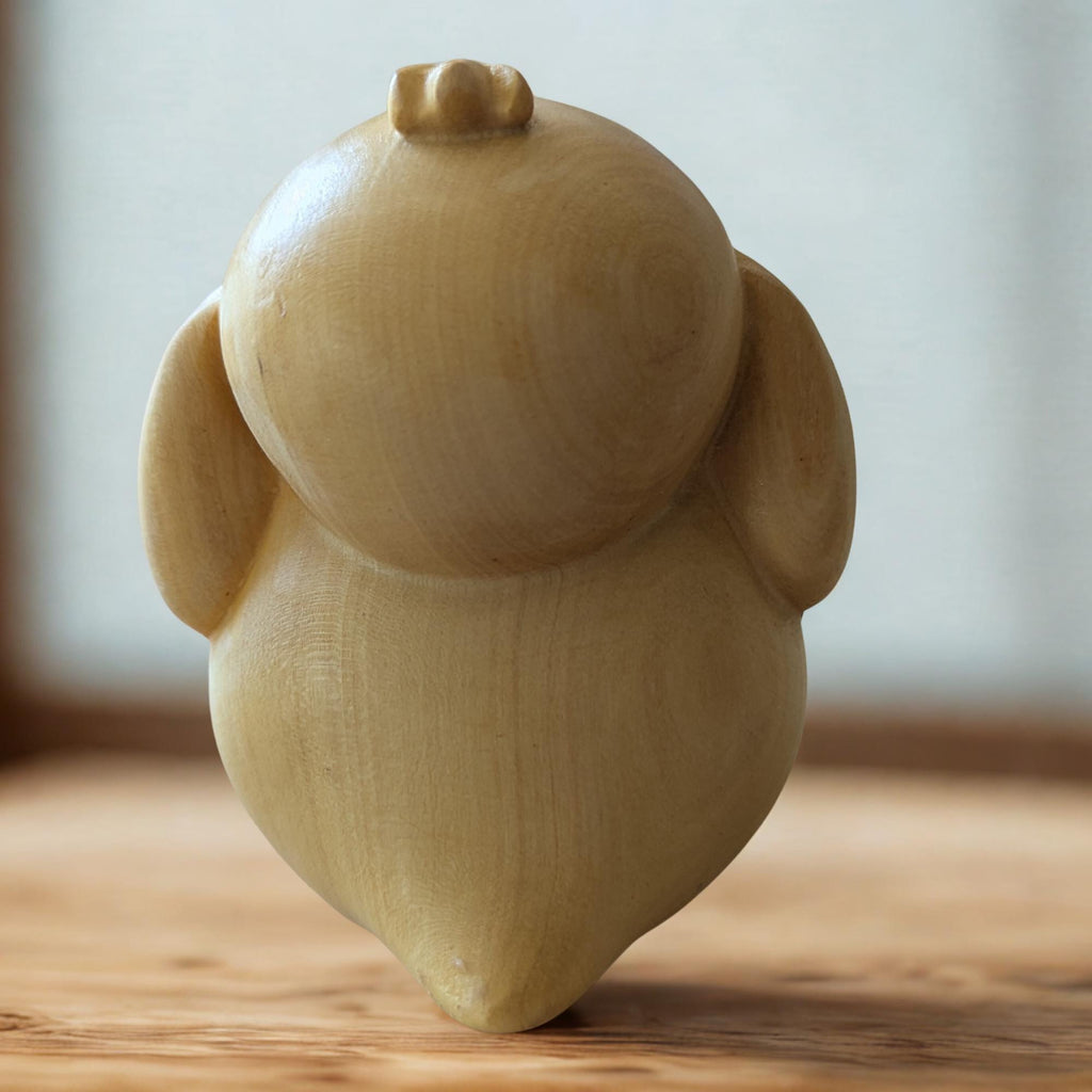 Wooden owl figurine on a wooden surface 