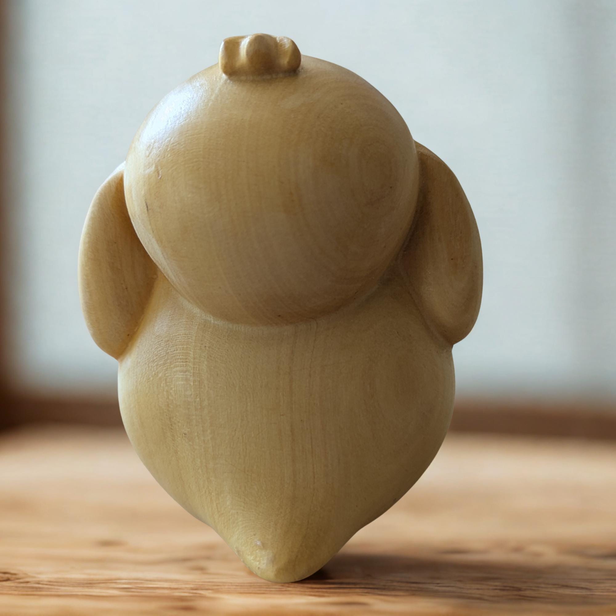 Wooden owl figurine on a wooden surface 