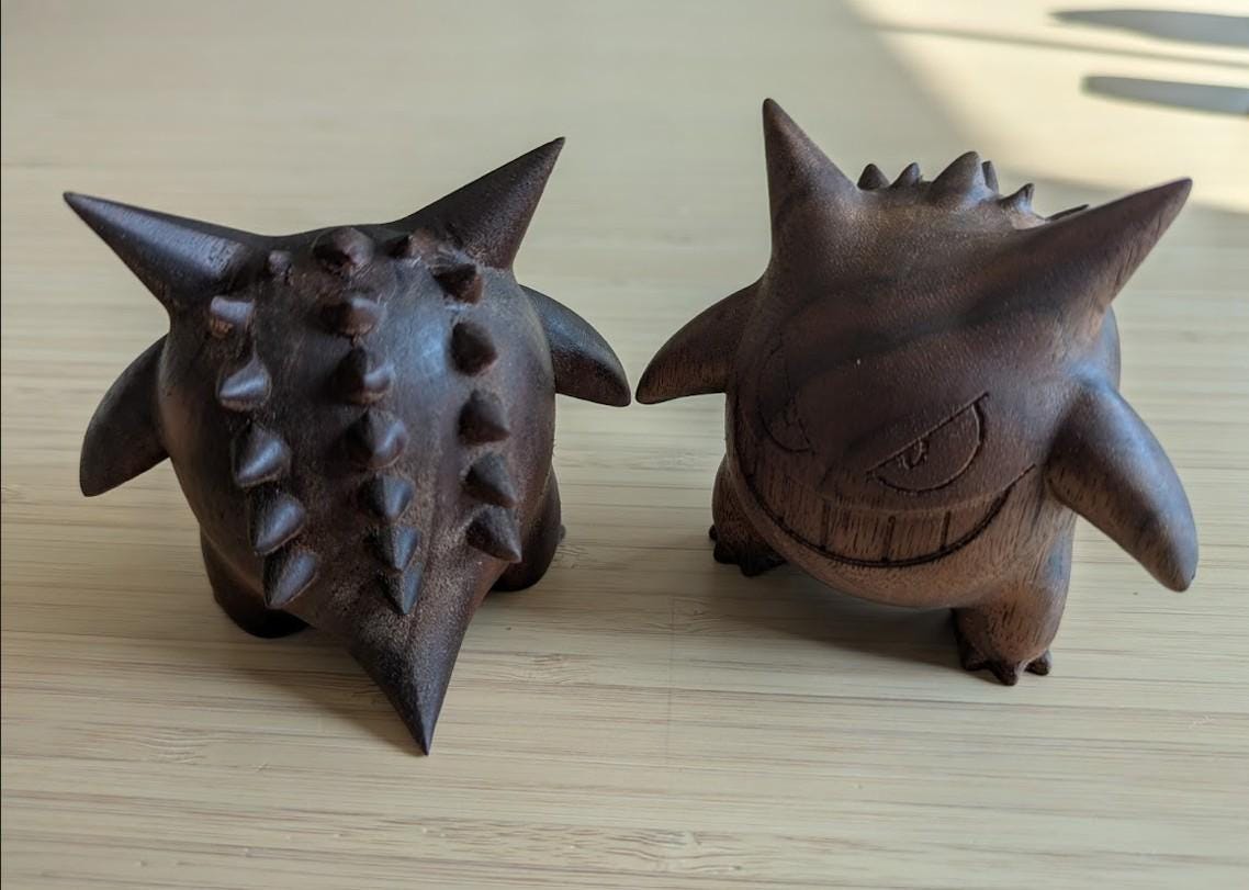 Two dark brown ceramic figurines with spiky textures
